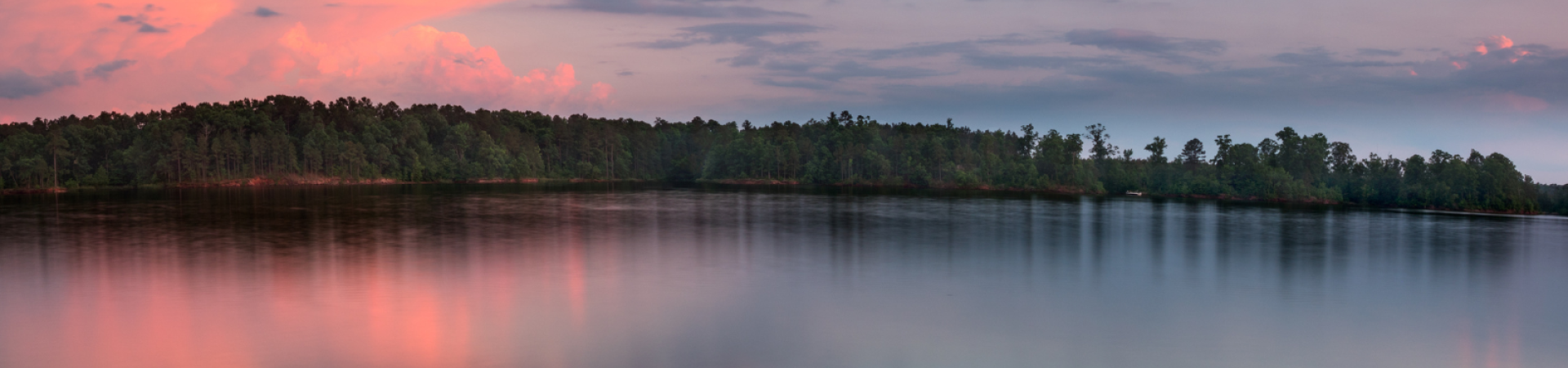 Lake at sunset with trees in the background