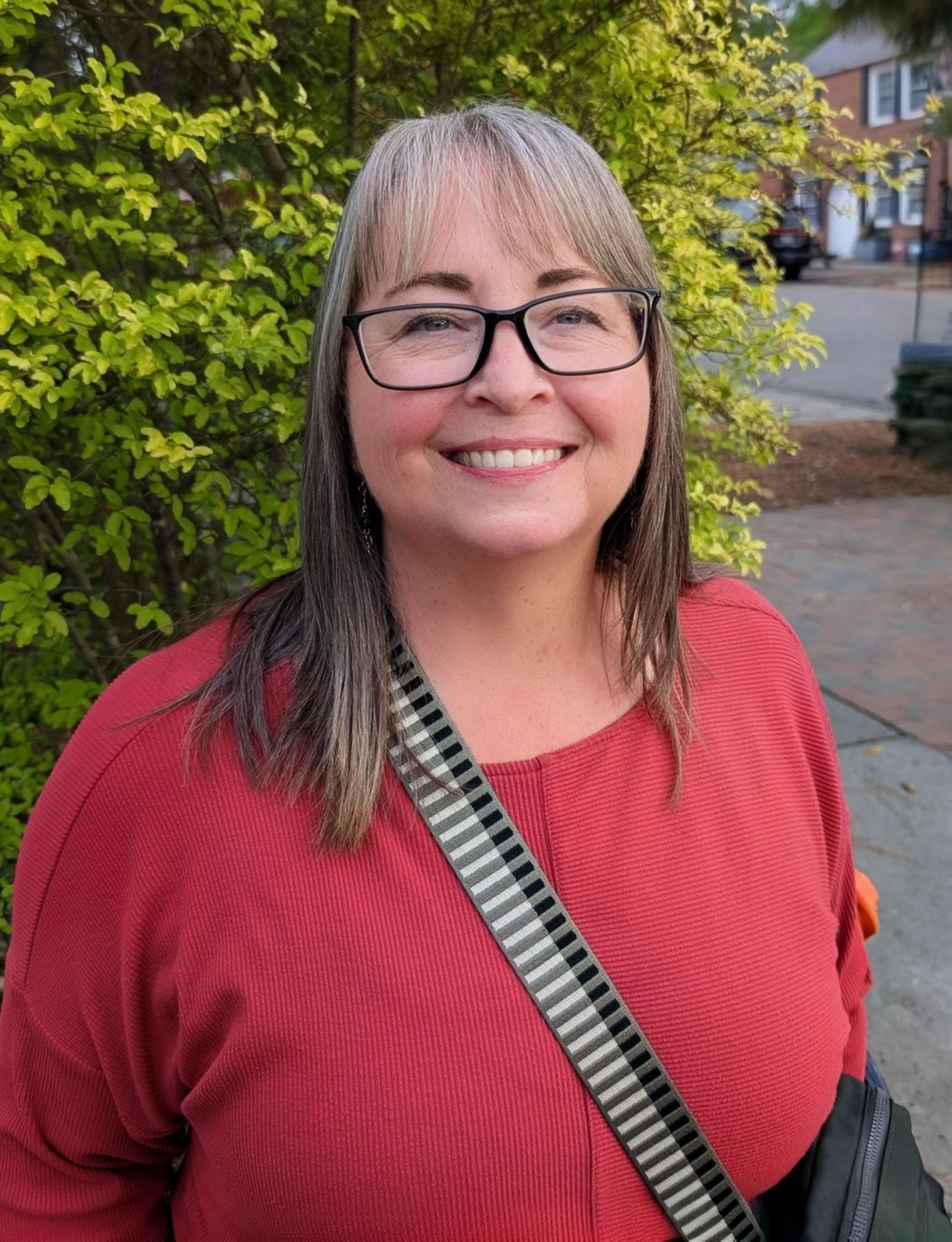 Woman wearing glasses and red shirt smiling